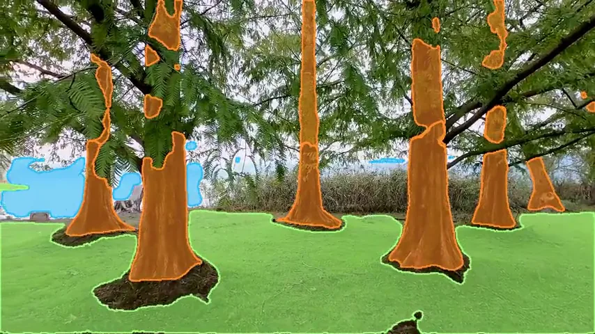Plantación de árboles con los troncos pintados de naranja, el suelo de verde y el cielo de celeste.